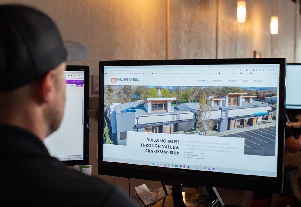 Person viewing construction website on computer monitor.