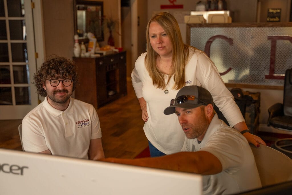 Team collaborating at a computer screen in office.