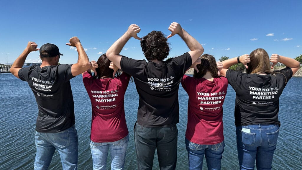 Group showing marketing shirts by the water.