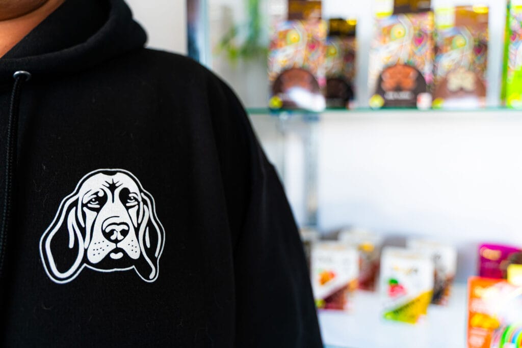 Hoodie with dog logo, snacks on shelves behind