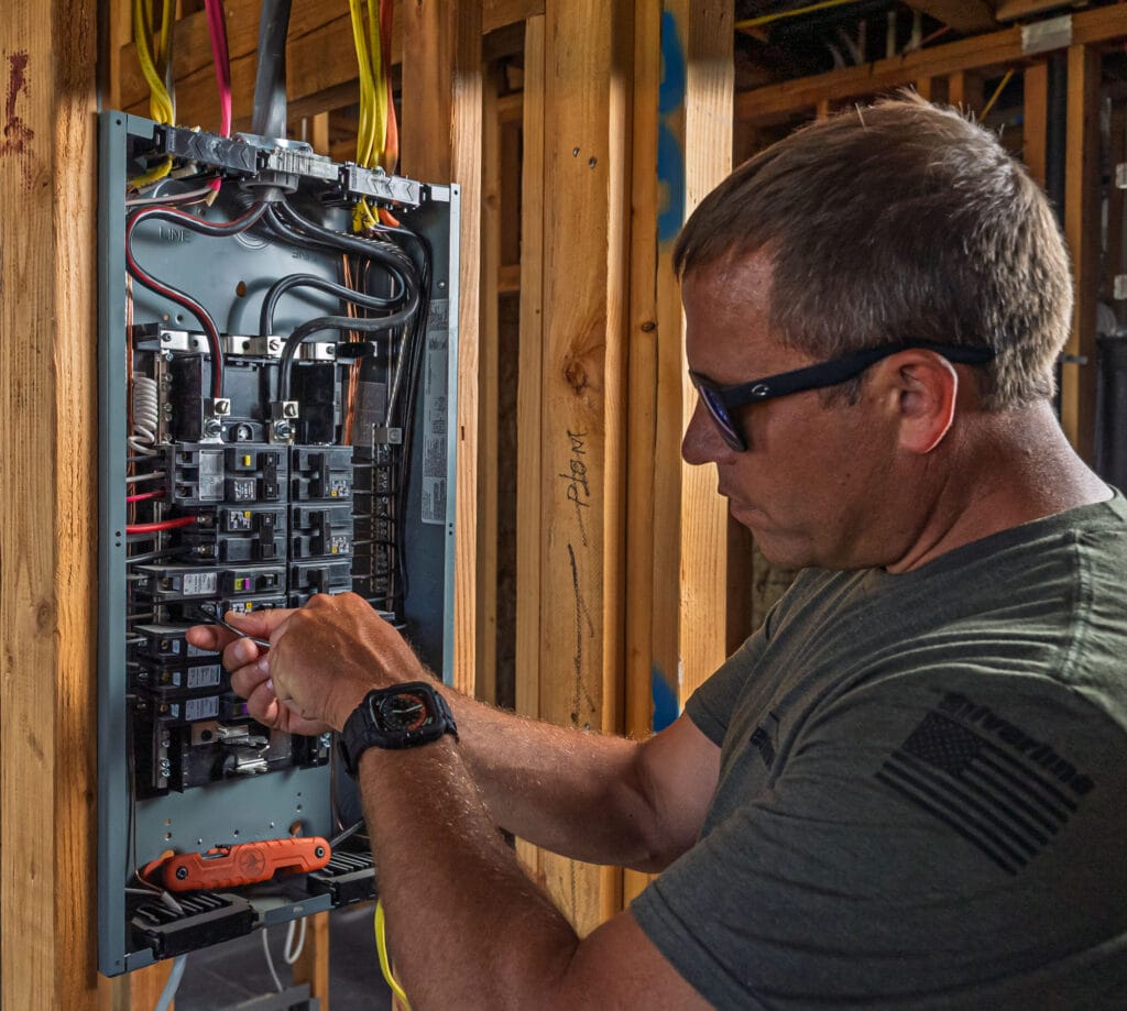 Electrician working on circuit breaker panel.
