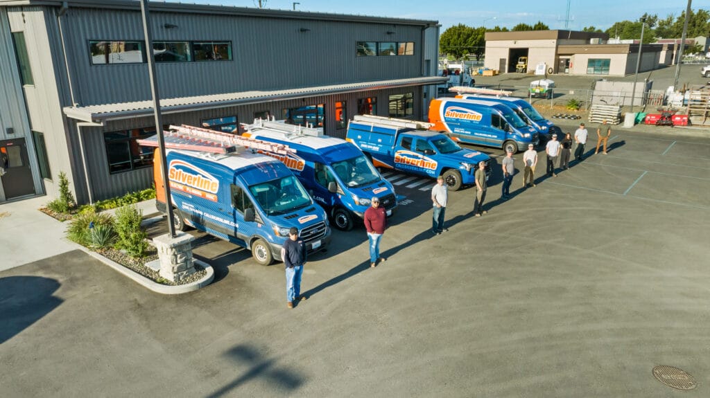 Silverline vans and team outside office building.
