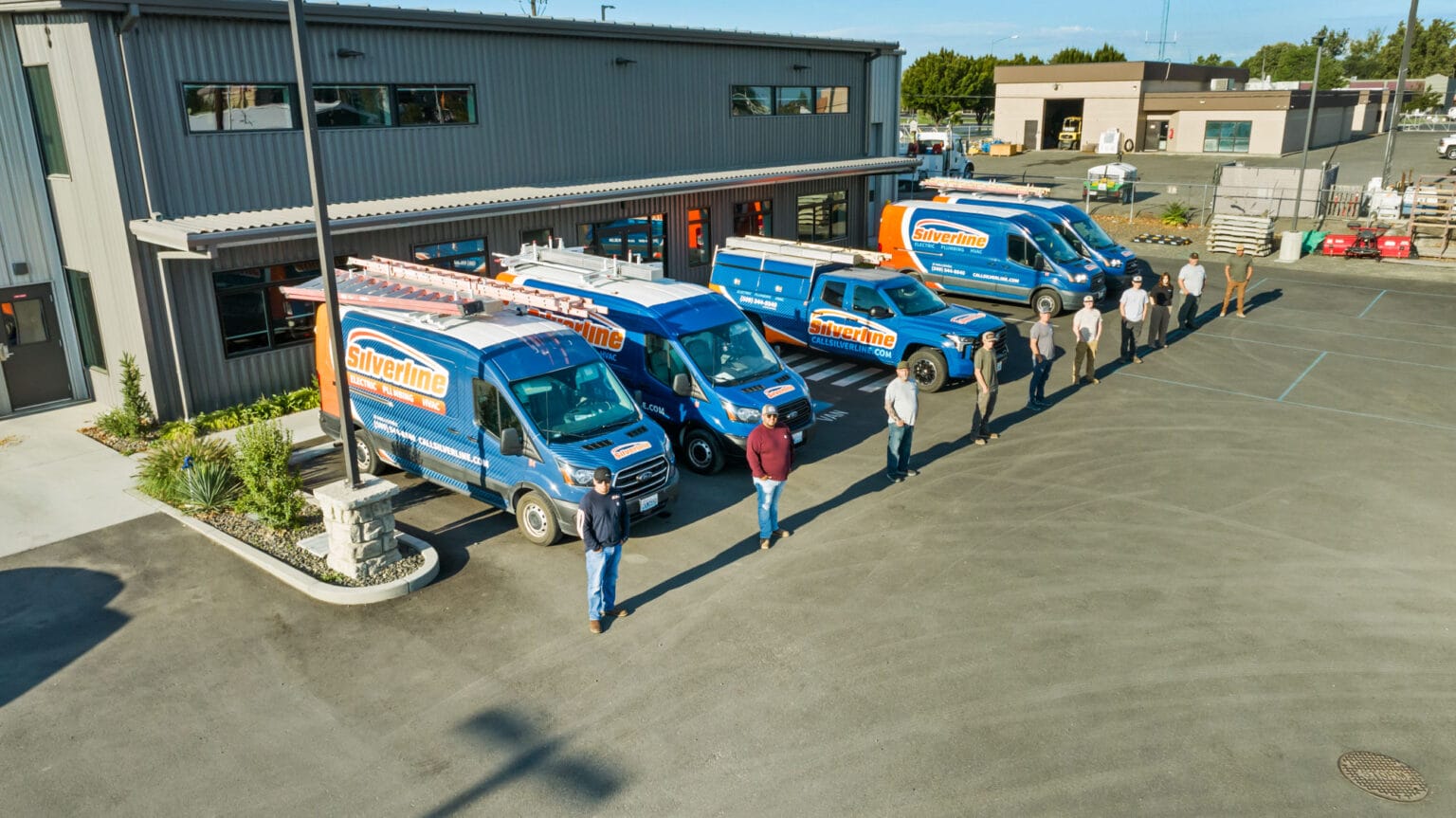 Silverline vans and team outside office building.