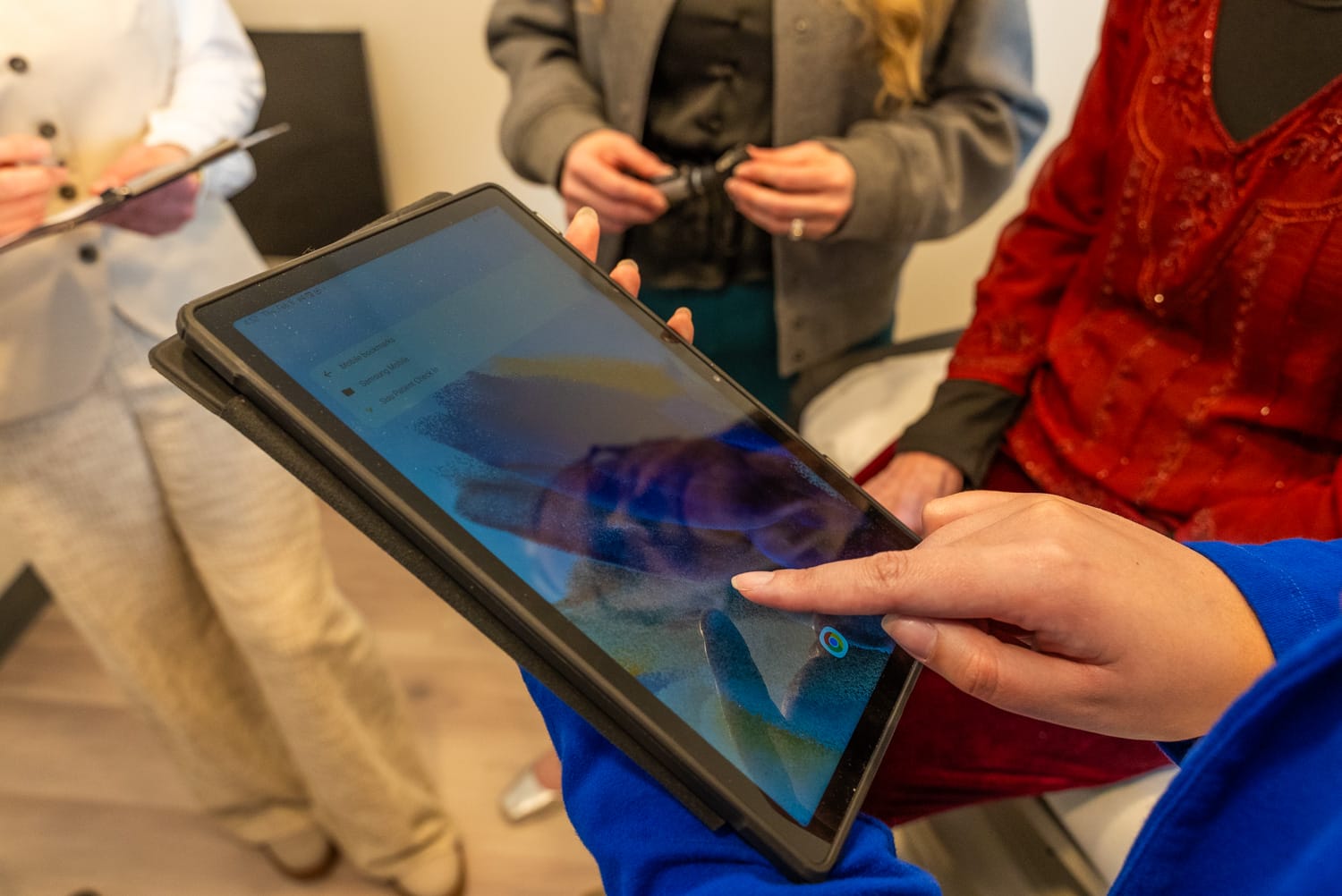 People using a tablet in a meeting.