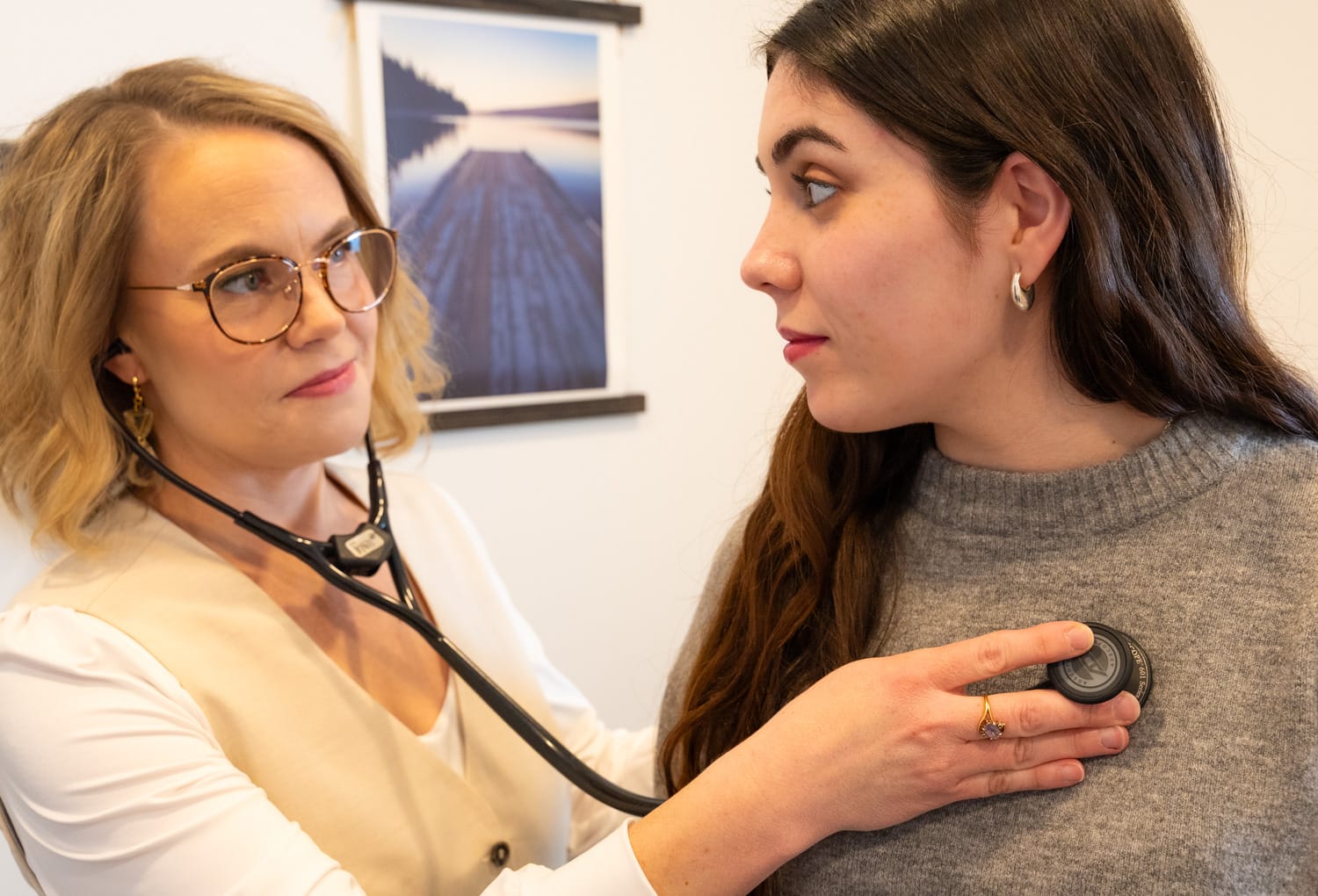 Doctor using stethoscope on patient's chest.