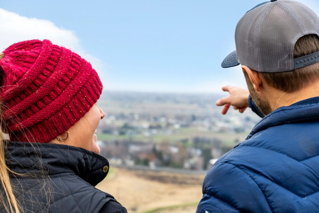 Couple pointing at scenic rural view.