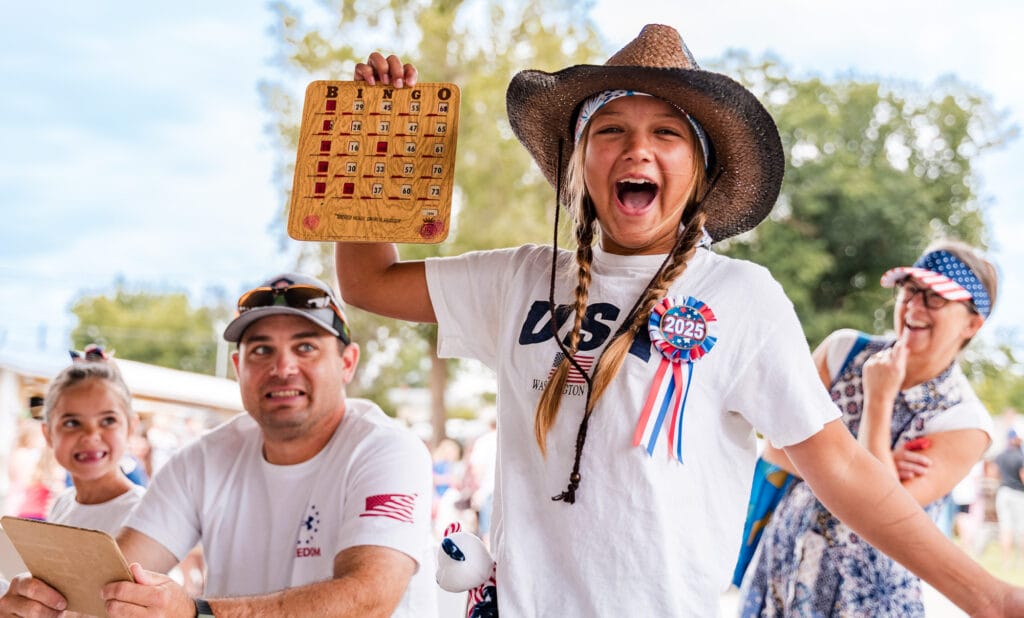 Excited girl with bingo card and USA attire.