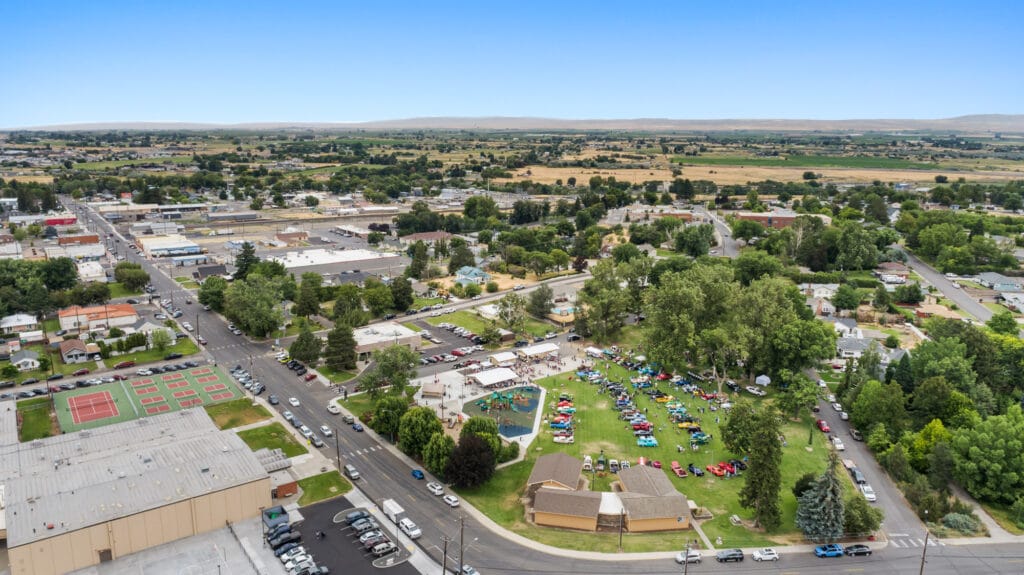 Aerial view of a town and park with cars.
