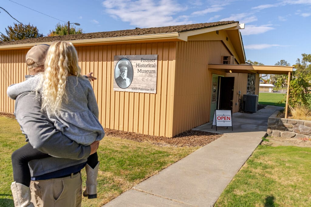 Person pointing at Prosser Historical Museum entrance.
