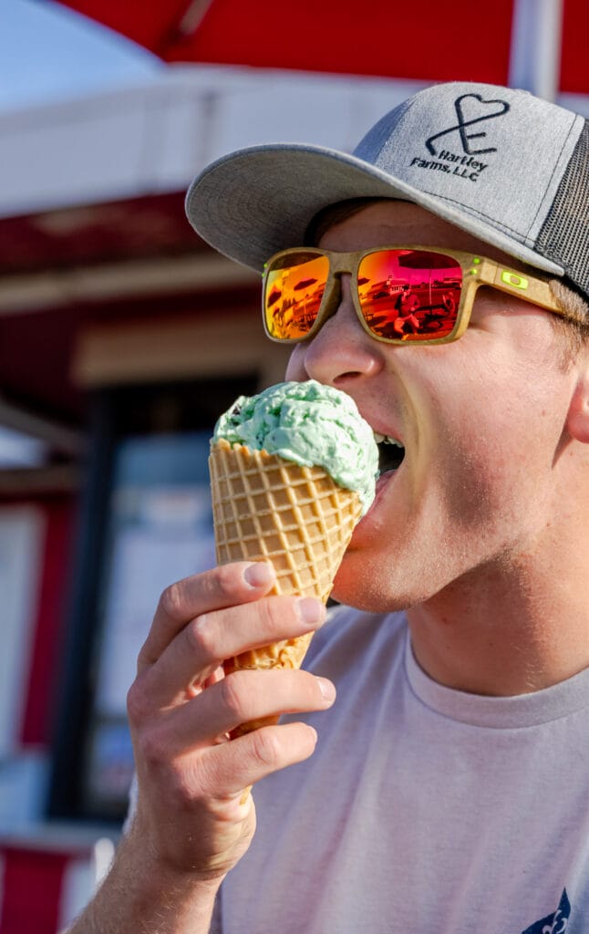 Person enjoying mint ice cream cone outdoors.