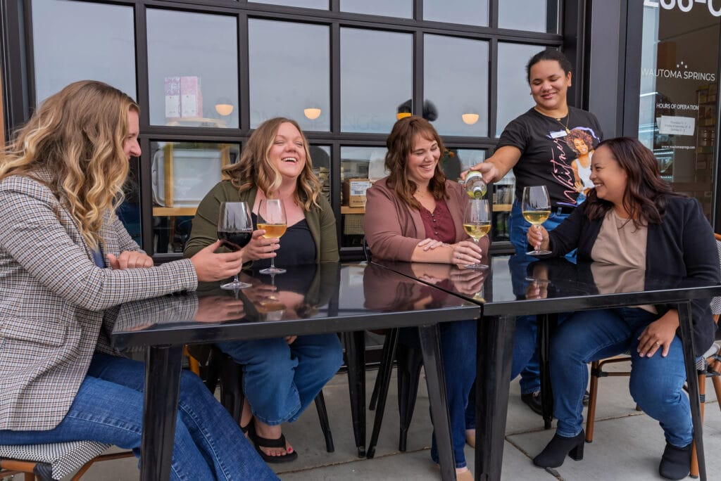 Friends enjoying wine at an outdoor cafe.