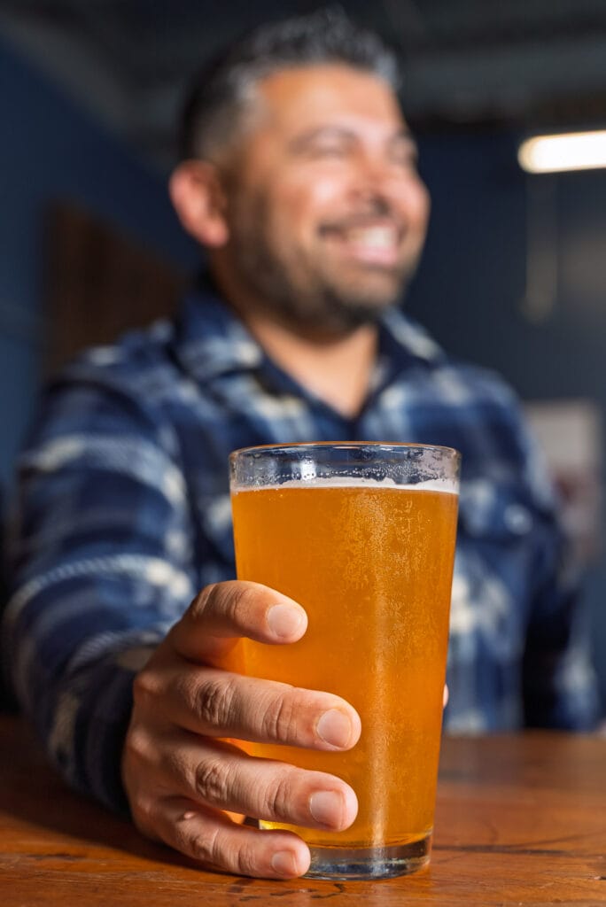 Smiling man holding a glass of beer.