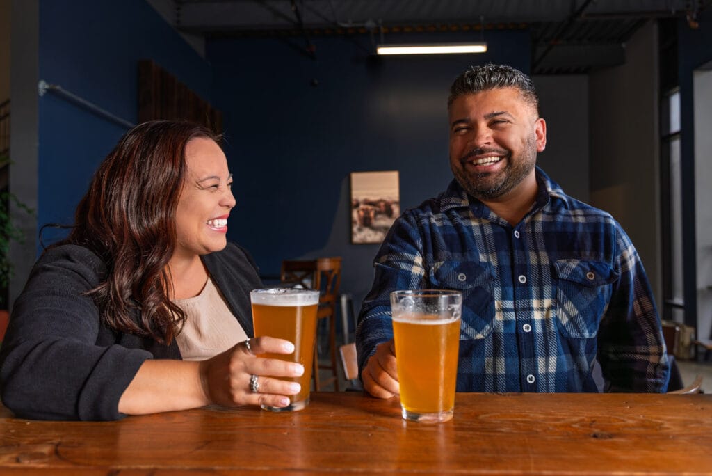 Smiling friends enjoying drinks at a bar.