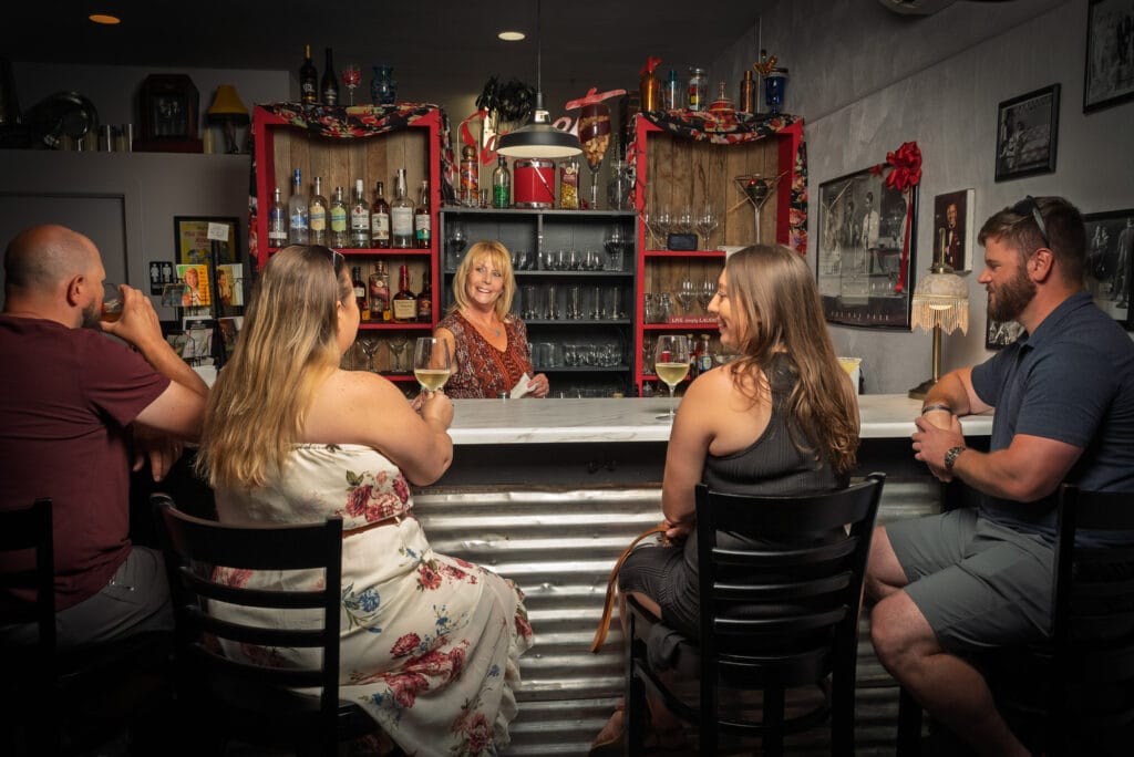 Four people enjoying drinks at a bar.