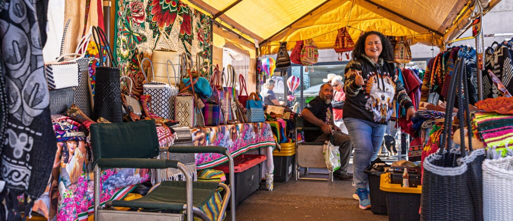 Colorful market stall with vibrant woven bags.