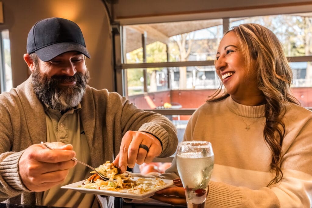 Couple enjoying nachos at a cozy restaurant.