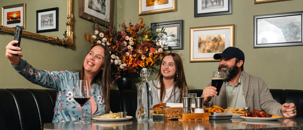 Family taking selfie while dining together in restaurant.
