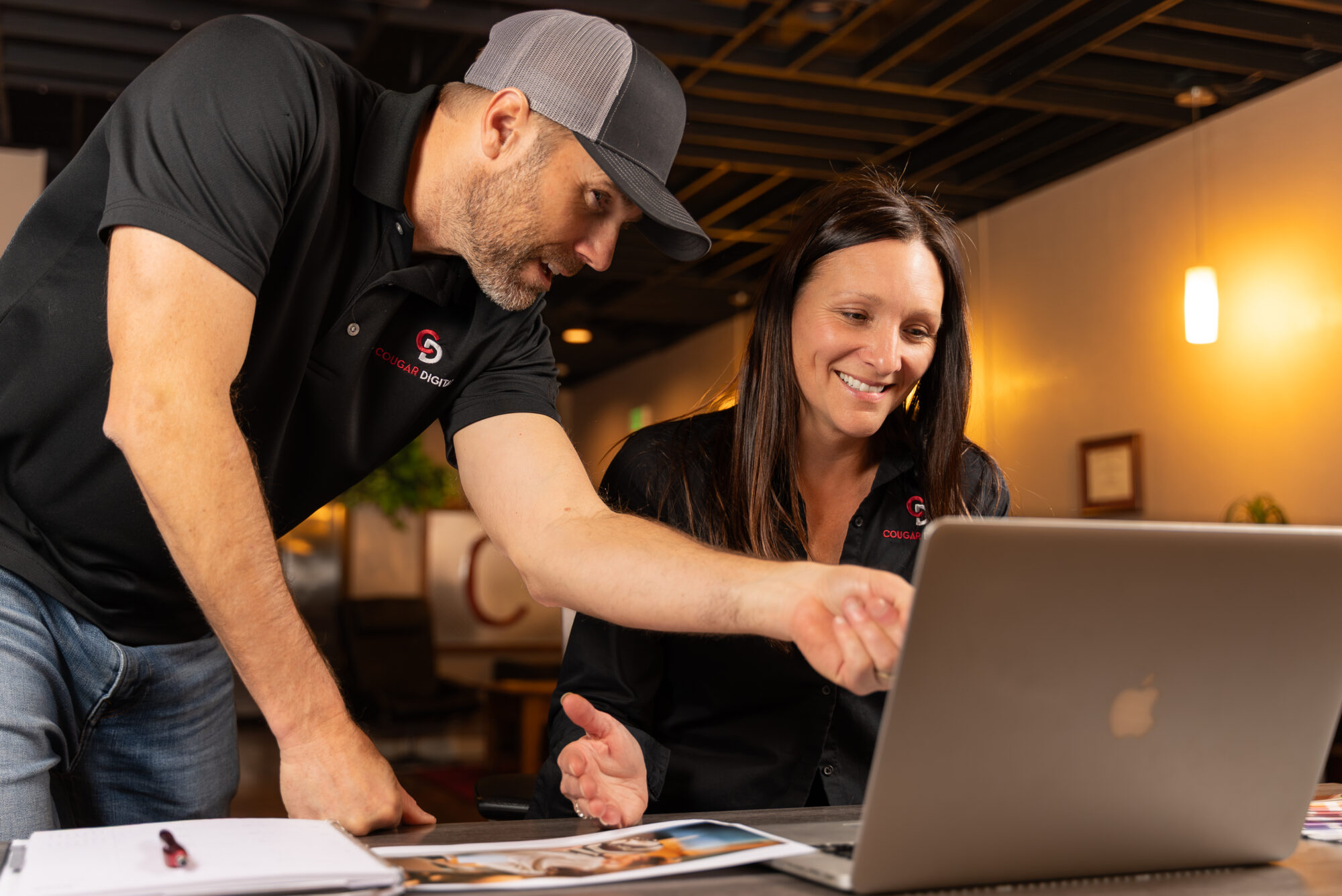 Two colleagues discussing project on laptop