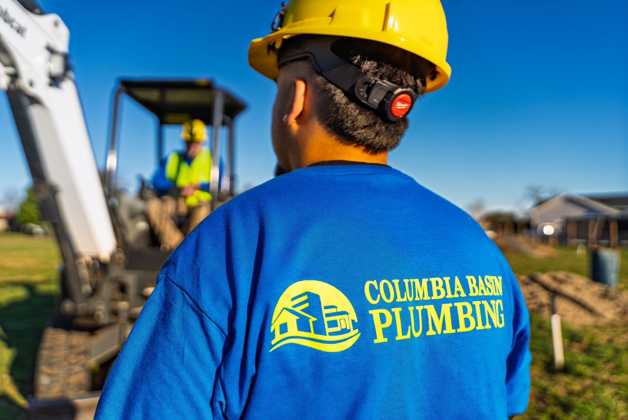 Construction worker in hard hat near excavator